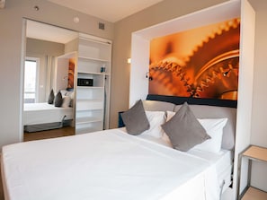 A bedroom with a bed, pillows, a wardrobe, and a wall with a mechanical gear design. - Mercure São Bernardo Do Campo (São Bernardo do Campo)