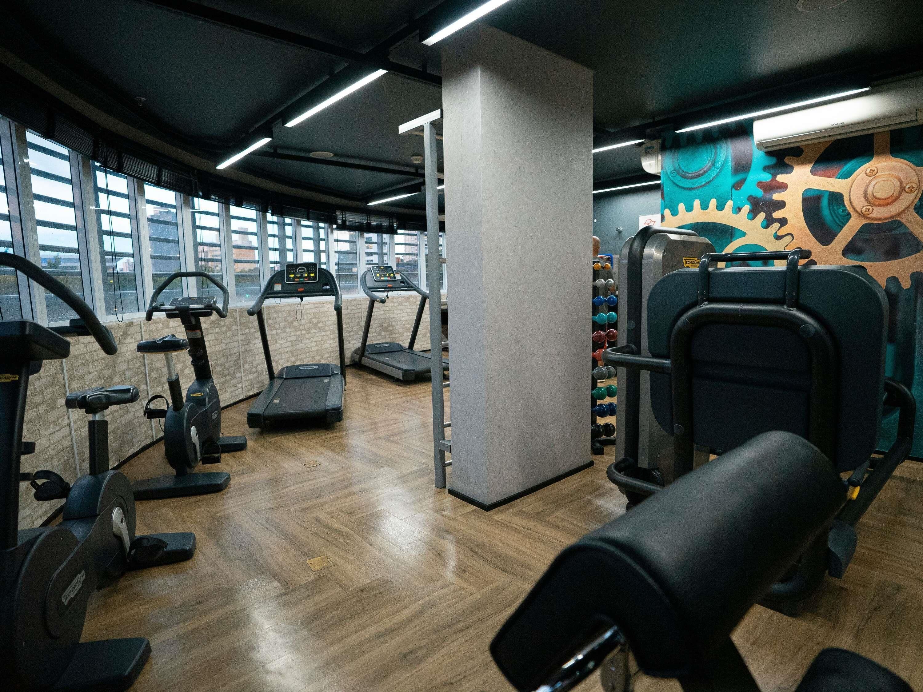 A gym with treadmills, elliptical machines, and weightlifting equipment.