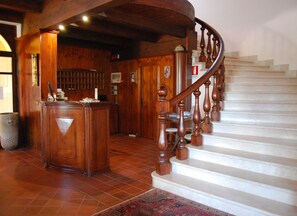 A wooden reception desk with a tiled floor and a staircase with wooden balusters. - Fattoria il Borghetto (Isola di Capo Rizzuto)