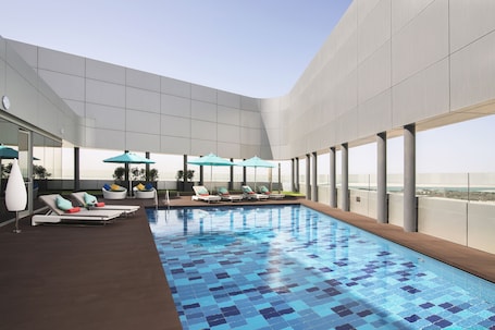 Outdoor pool, open 7:00 AM to 9:00 PM, pool umbrellas, pool loungers. Pearl Rotana Capital Centre