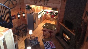 A cozy cabin interior with a kitchen, dining area, and fireplace. - Secluded mountain cabin 5 acres , all rooms with view,  hear soothing waterfall (Maggie Valley)