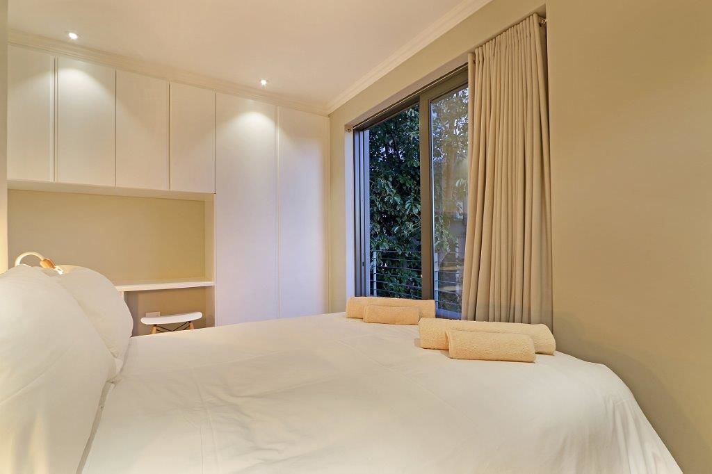 Une chambre à coucher avec un grand lit, une table de chevet et une armoire.