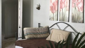 A bedroom with a bed, a nightstand, a wall-mounted light, and three paintings of pink flowers. -  Minutes from Downtown, Pittsburgh’s international airport,  & Sports’ arenas! (Pittsburgh)