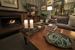 Una sala de estar acogedora con chimenea, una mesa de centro de madera y un sofá cómodo.