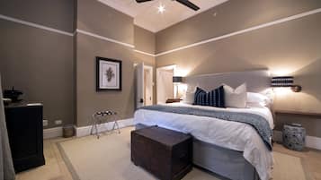 A bedroom with a bed, bedside tables, a ceiling fan, and a nightstand.