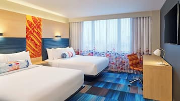 A hotel room with two beds, a desk, a chair, and a large window with curtains.