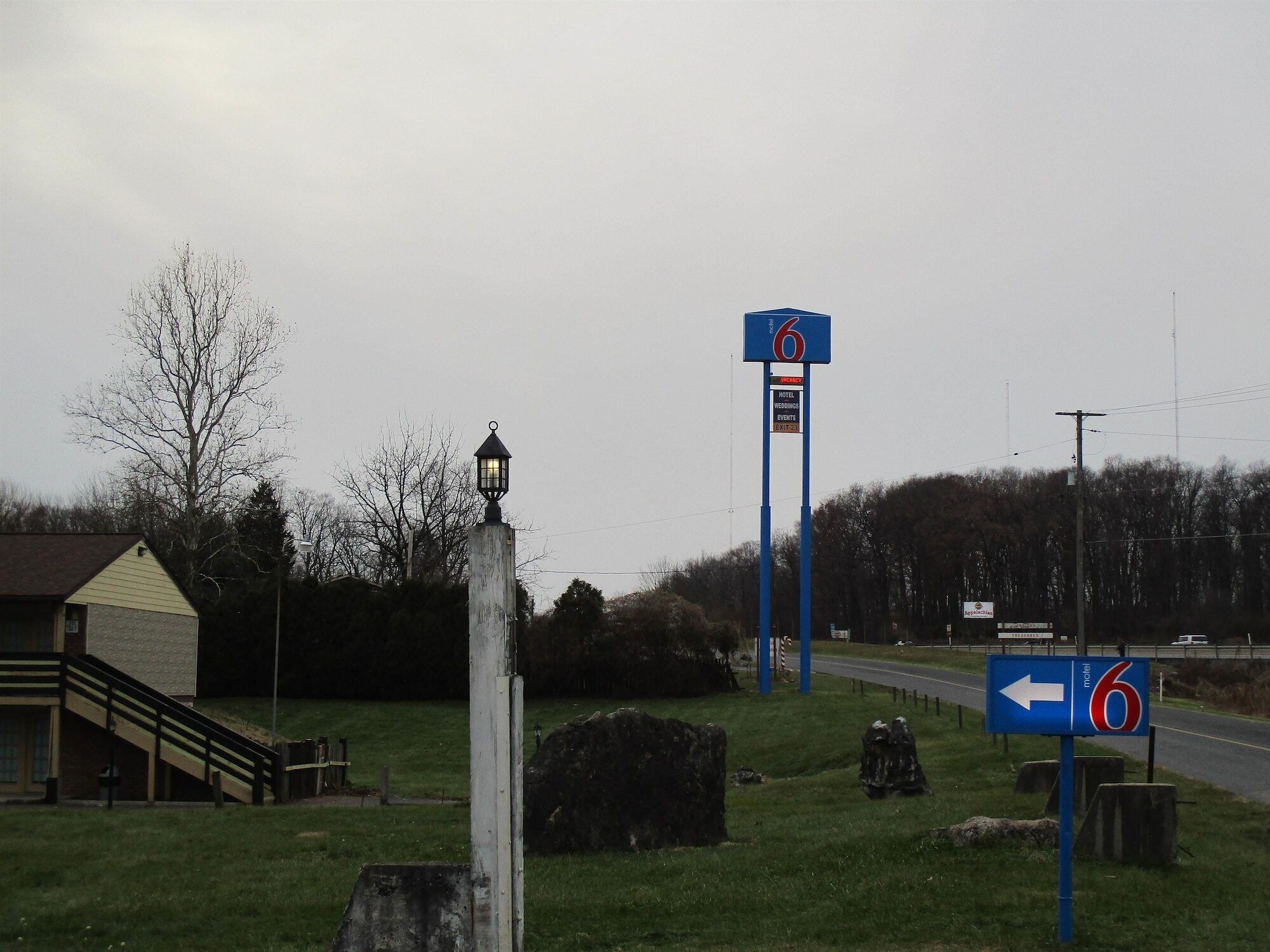 A motel sign with a directional arrow and a number '6' indicating the route.