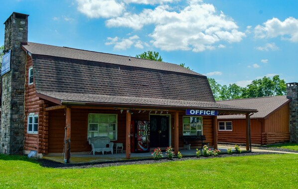 A log cabin-style building with a porch and a sign that reads "OFFICE". - Motel 6 Shartlesville, PA (Bernville)