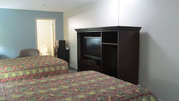 A hotel room with two beds, a television, a desk, and a chair.