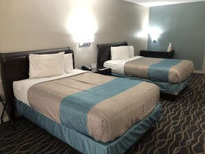 A hotel room with two beds, a nightstand, a lamp, and a carpeted floor. - Motel 6 Shartlesville, PA (Bernville)