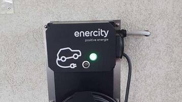 An electric vehicle charging station with a cable connected to it.