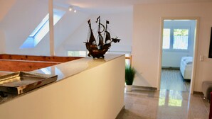 Une cuisine moderne avec une lucarne, une maquette de bateau et une vue sur une chambre à coucher.