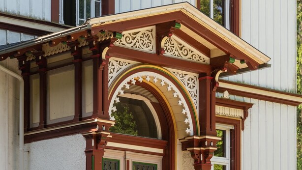 Un edificio de estilo arquitectónico tradicional, con una entrada destacada que presenta arcos decorativos y una fachada simétrica.