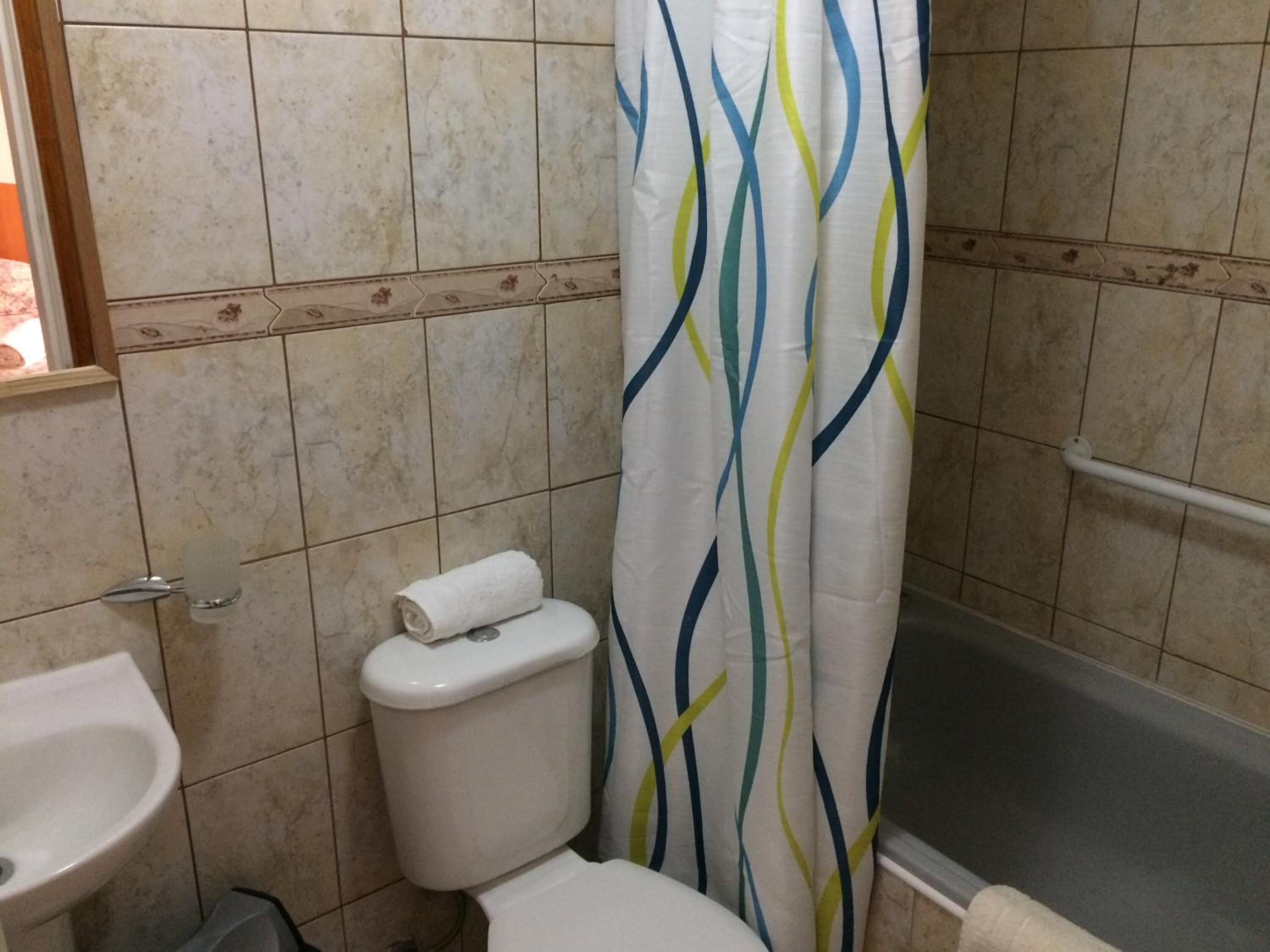 A bathroom with a toilet, sink, and bathtub.