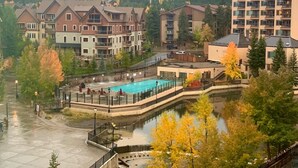 Een resort met meerdere gebouwen, een zwembad en een berg op de achtergrond.