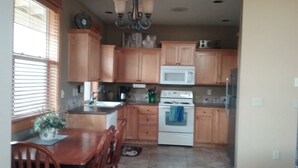 Una cocina con armarios de madera, una estufa blanca, un microondas y un lavabo.