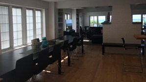 Eine geräumige Küche mit einer langen Arbeitsplatte, eingebauten Regalen und Blick ins Freie.