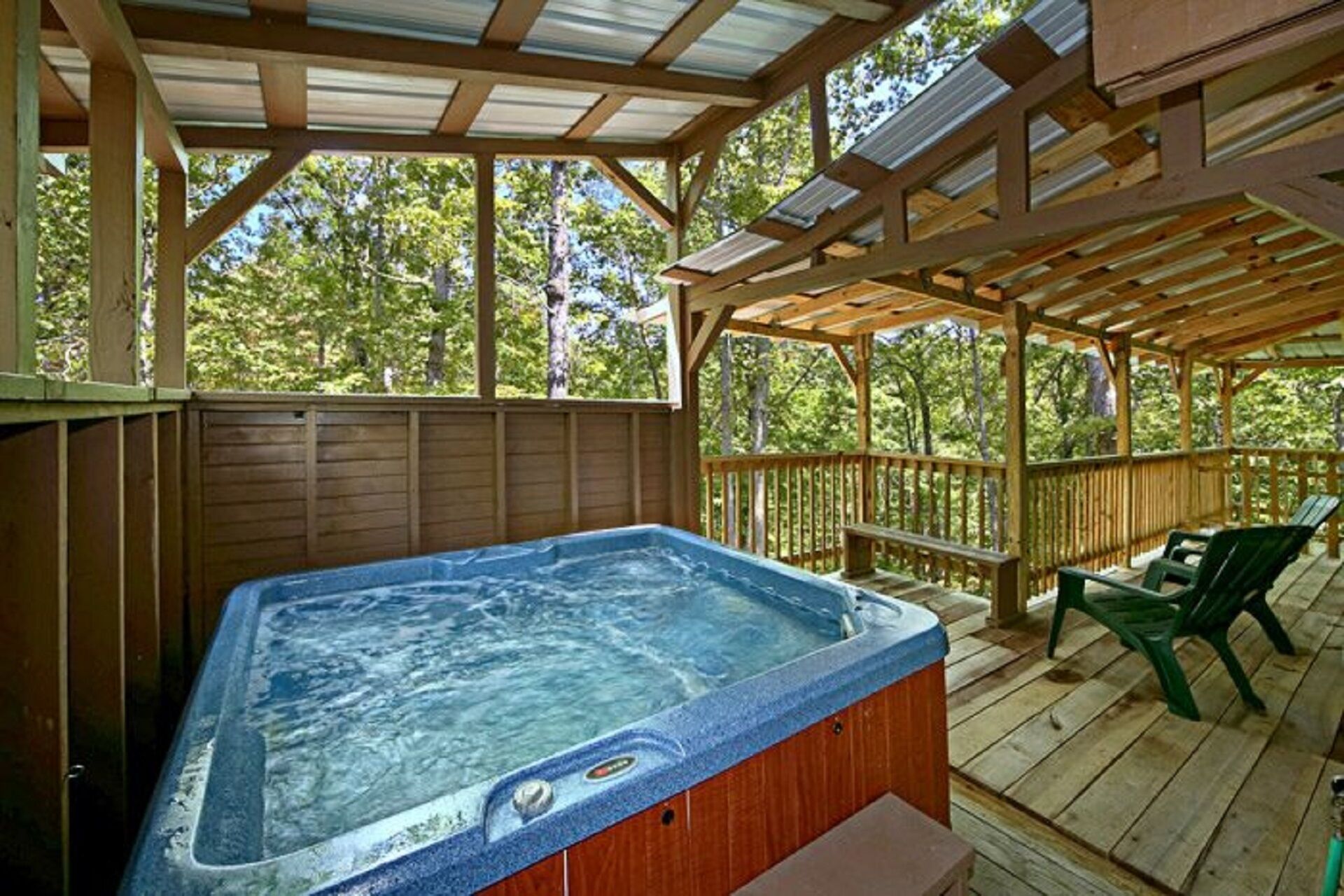 Ein Whirlpool auf einer Holterrasse, darüber eine Holzpergola.