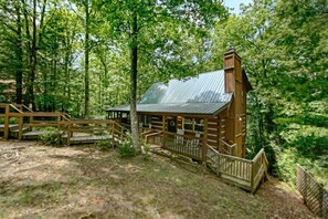 Eine rustikale Holzhütte mit Metalldach, einer Holzterrasse und einer kleinen Veranda.