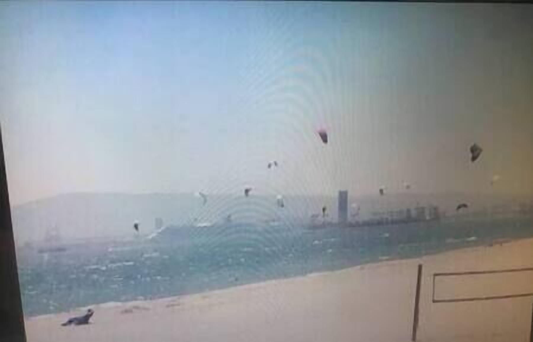 Ein Strand mit sandigem Ufer und Blick aufs Meer.