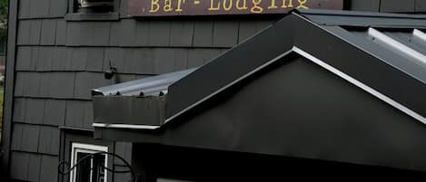A building with a sign reading 'Bar-Lodging' and an air conditioning unit mounted on the exterior wall.