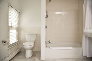 Un baño con inodoro, bañera y ducha.