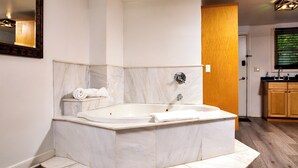 A modern bathroom with a freestanding bathtub, a towel rack, and a wooden cabinet.