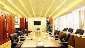 A conference room with a long table, chairs, a TV screen, and a plant. - GreenTree Inn Qingdao Development District SDUST Express Hotel (Qingdao)