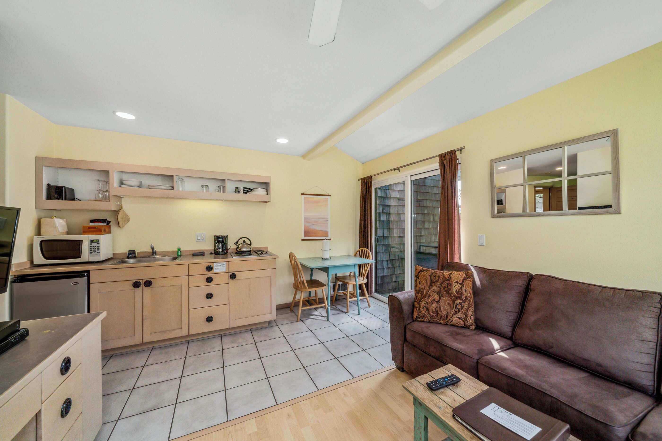 A compact living space with a kitchenette, a dining area, and a seating area with a couch and table.