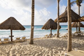 On the beach, white sand, beach cabanas, sun loungers