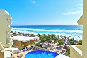 A resort with a pool, beach, and ocean view.