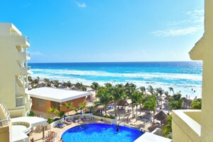 A resort with a pool, beach, and ocean view.