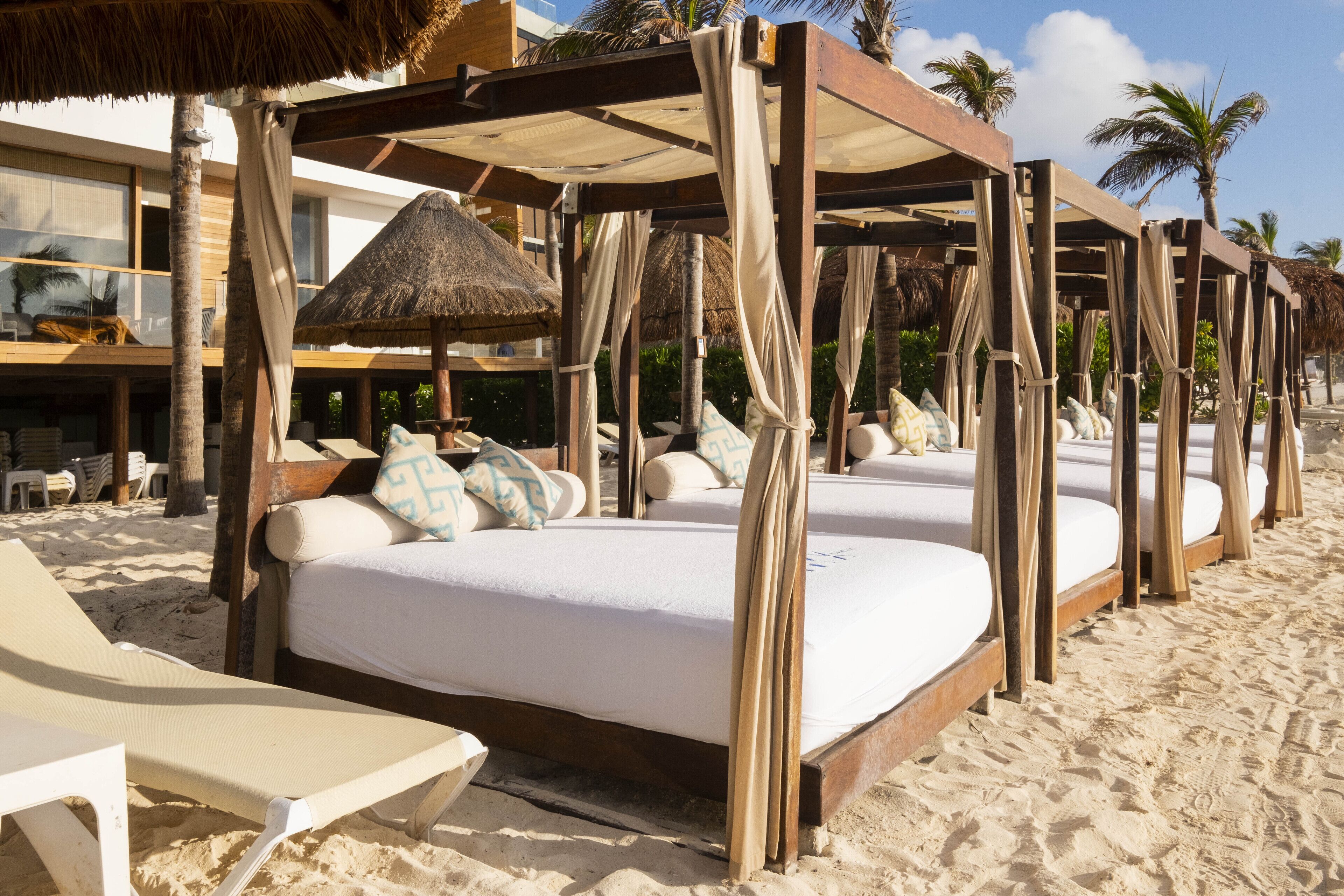 En la playa, playa de arena blanca y camas de playa (con cargo) 