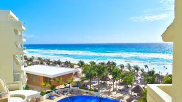 Alberca al aire libre, sombrillas en la alberca y camastros