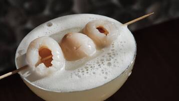 Een cocktail met drie bolvormige versieringen op een schuimend oppervlak.