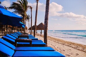 On the beach, white sand, beach cabanas, sun loungers