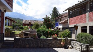 Une cour avec des marches en pierre, des plantes en pot et une vue sur les montagnes.