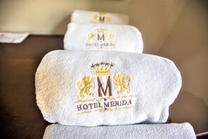 A set of towels with embroidered logos and text, likely from a hotel.
