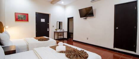 Una camera d'albergo con due letti, una televisione e un quadro appeso al muro.