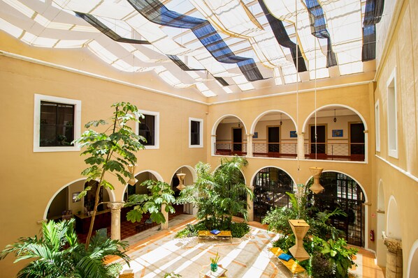 A spacious atrium with a high ceiling, large windows, and multiple arches. - Hotel Merida (Mérida)