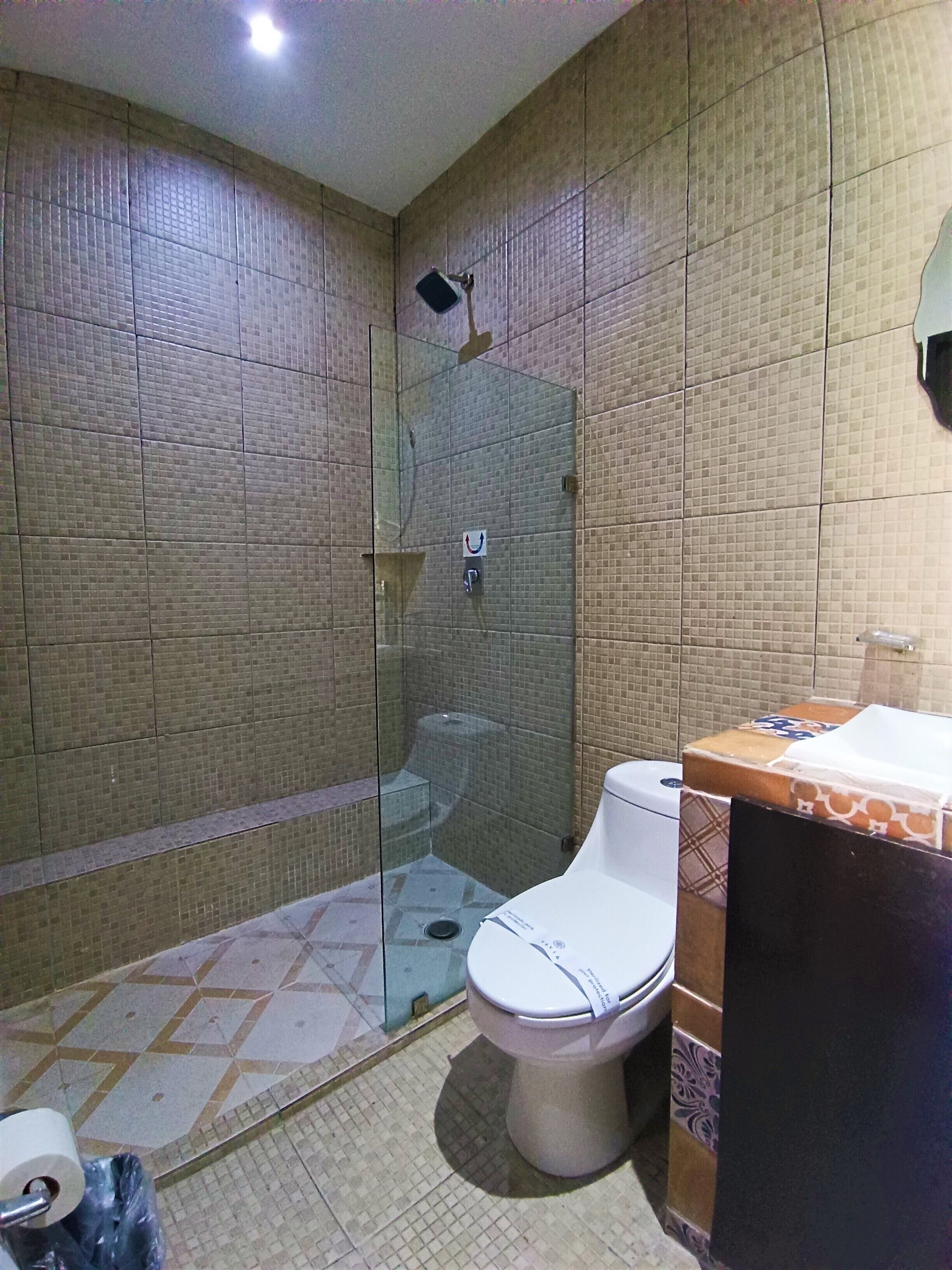 A bathroom with a shower, toilet, and sink.