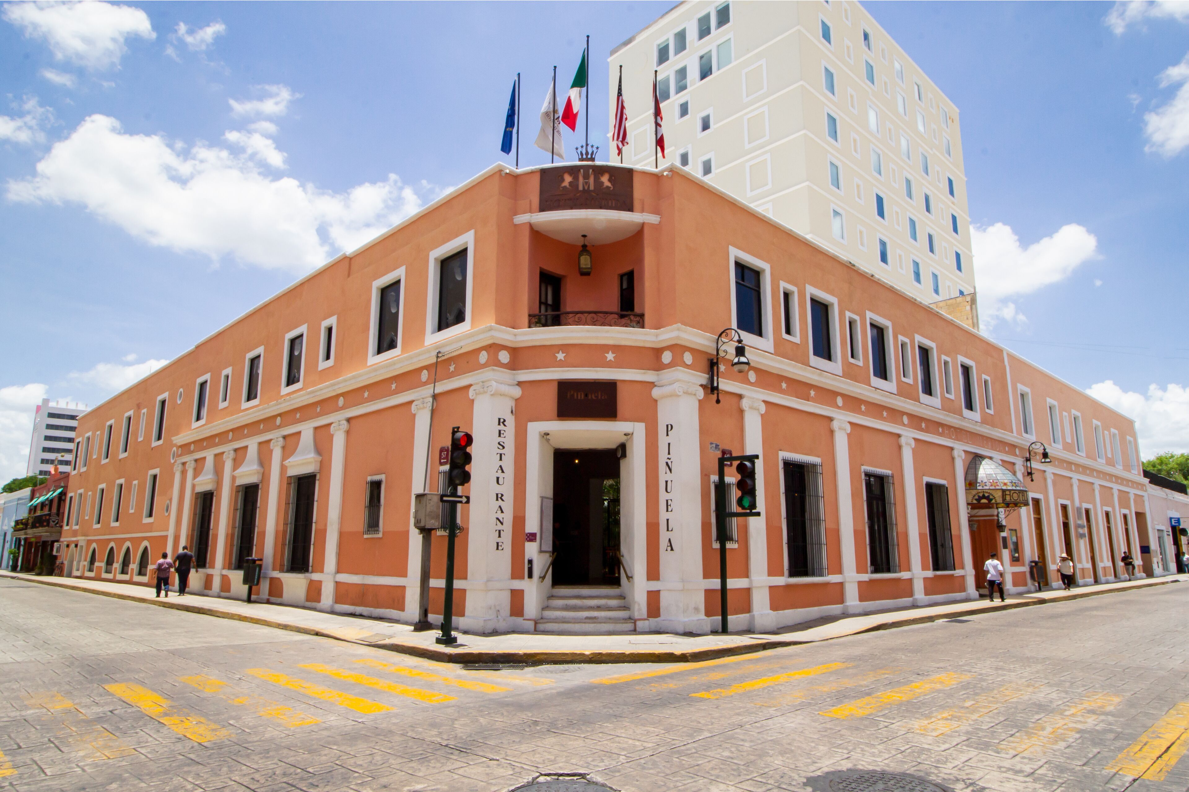 A historic building with a prominent entrance, columns, and flags.