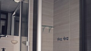 A modern bathroom with a glass-enclosed shower, a sink, and a toilet. - Hotel Avanty (Ipiales)