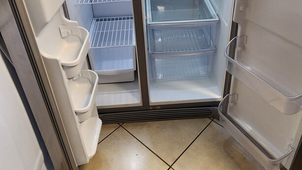 A refrigerator with multiple shelves and a freezer compartment, located in a kitchen with tiled flooring. - Experience Comfort and Convenience in the Heart of Knoxville (Knoxville)