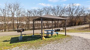 A park with a wooden pavilion, picnic tables, benches, and a trash can. - Experience Comfort and Convenience in the Heart of Knoxville (Knoxville)