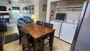 A compact living space with a dining area, a sofa, a TV, and a washing machine. - Experience Comfort and Convenience in the Heart of Knoxville (Knoxville)