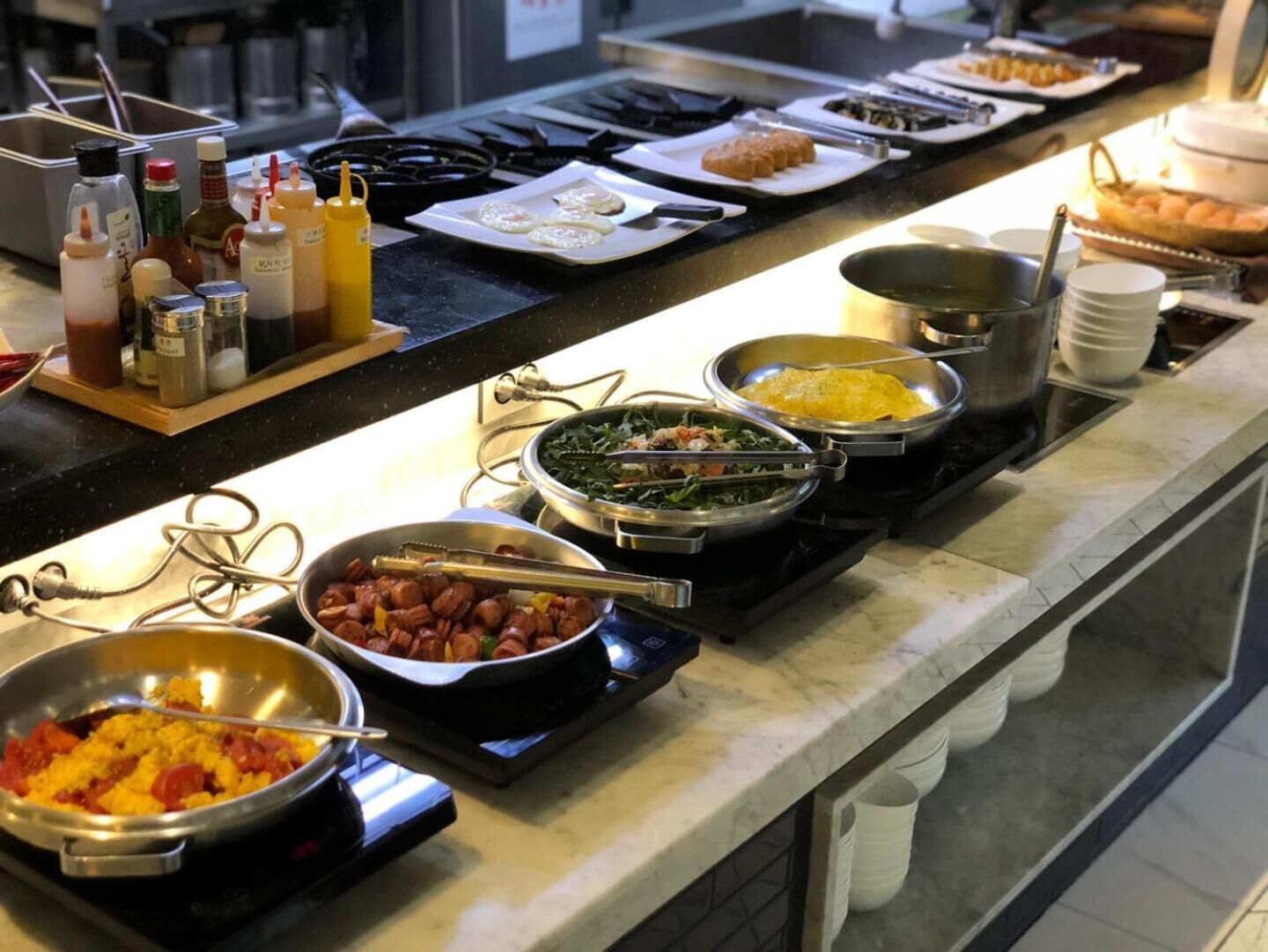 A buffet setup with various dishes and condiments.