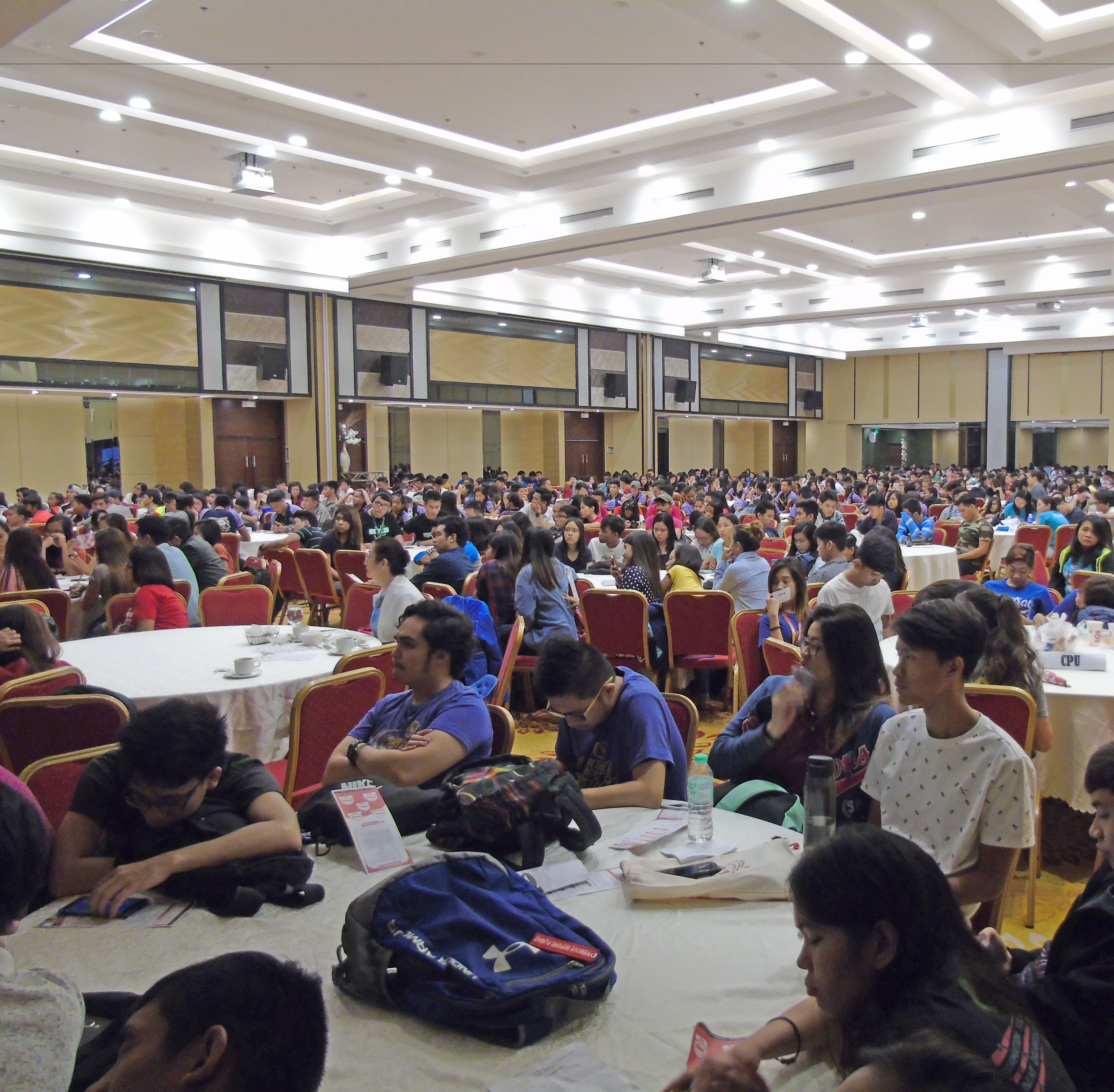 A large conference room with rows of tables and chairs, suitable for meetings or events.