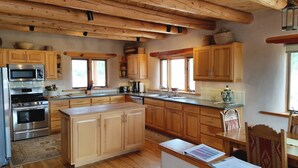 Una cucina con mobili in legno, un piano cottura in acciaio inossidabile e un'ampia finestra.