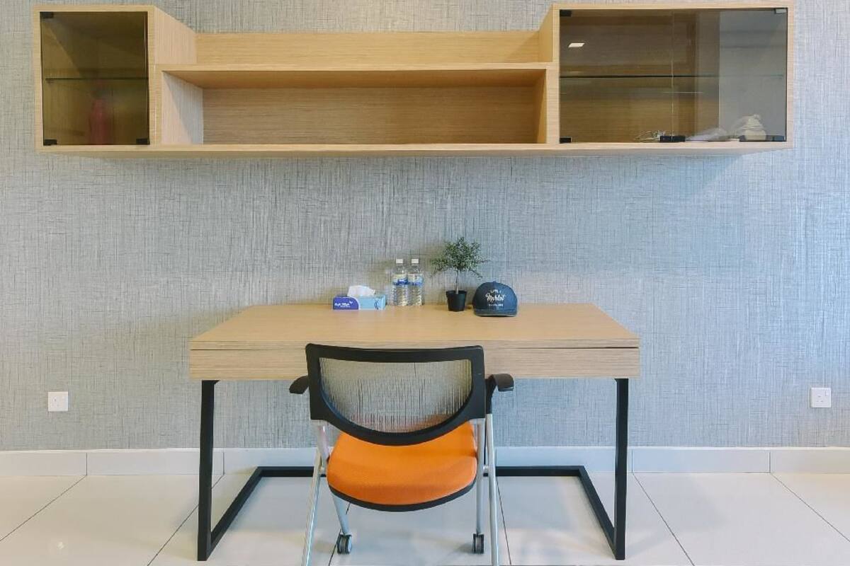 A modern room with a wooden table, a chair with wheels, and two wall-mounted shelves.